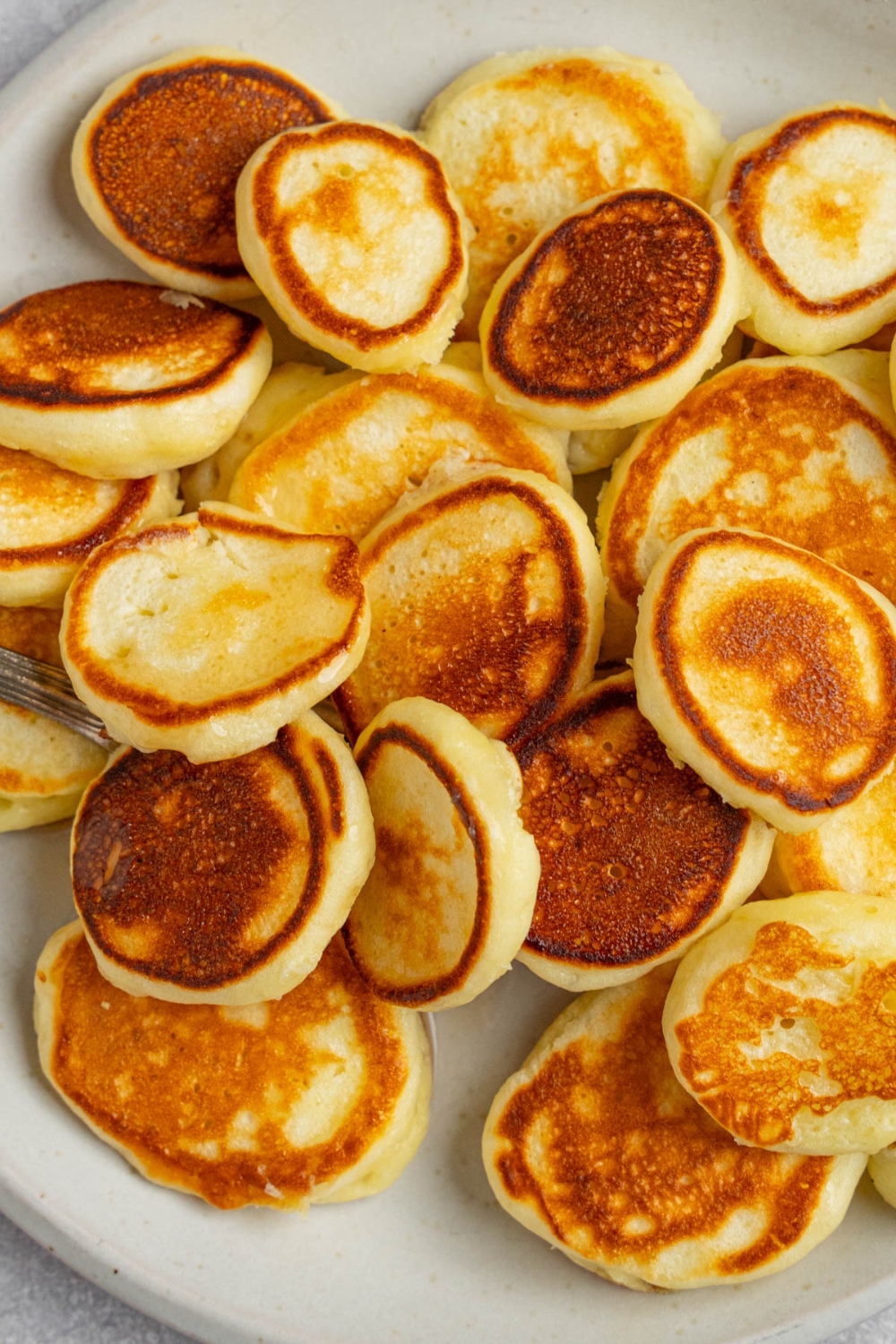 Mini pancakes on a white plate.