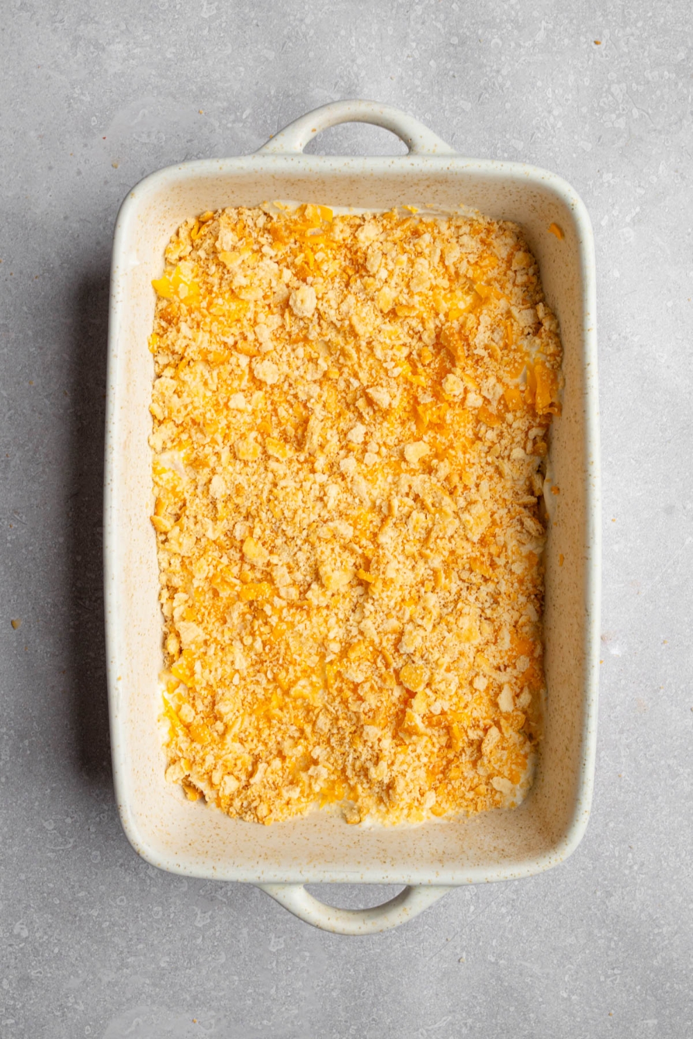 A baking dish with uncooked Neiman Marcus chicken casserole. The dish is on a white counter.