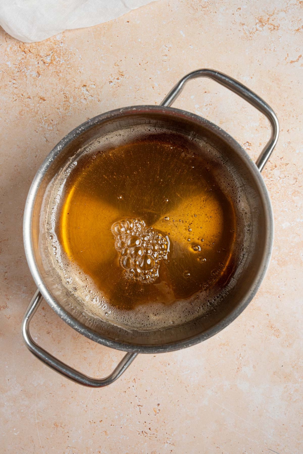 A stock pot with simmering apple juice. The pot is on a tan counter.