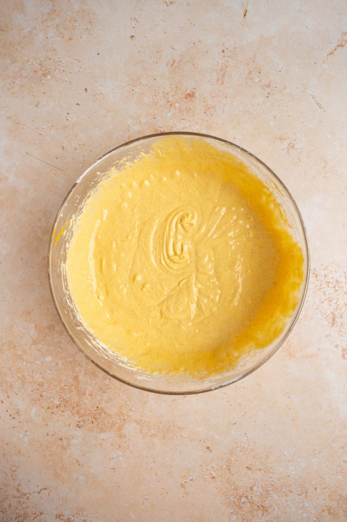 A glass bowl with whipped pumpkin fluff. The bowl is on a tan counter.