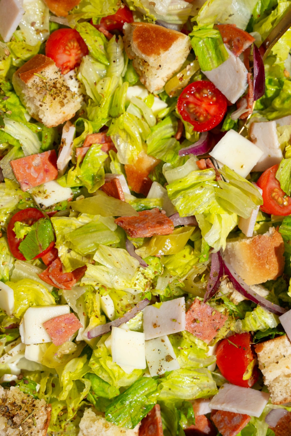 Copycat Jersey Mike's sub in a tub salad with mixed lettuce, tomatoes, provolone cheese, diced meats, and bread croutons.