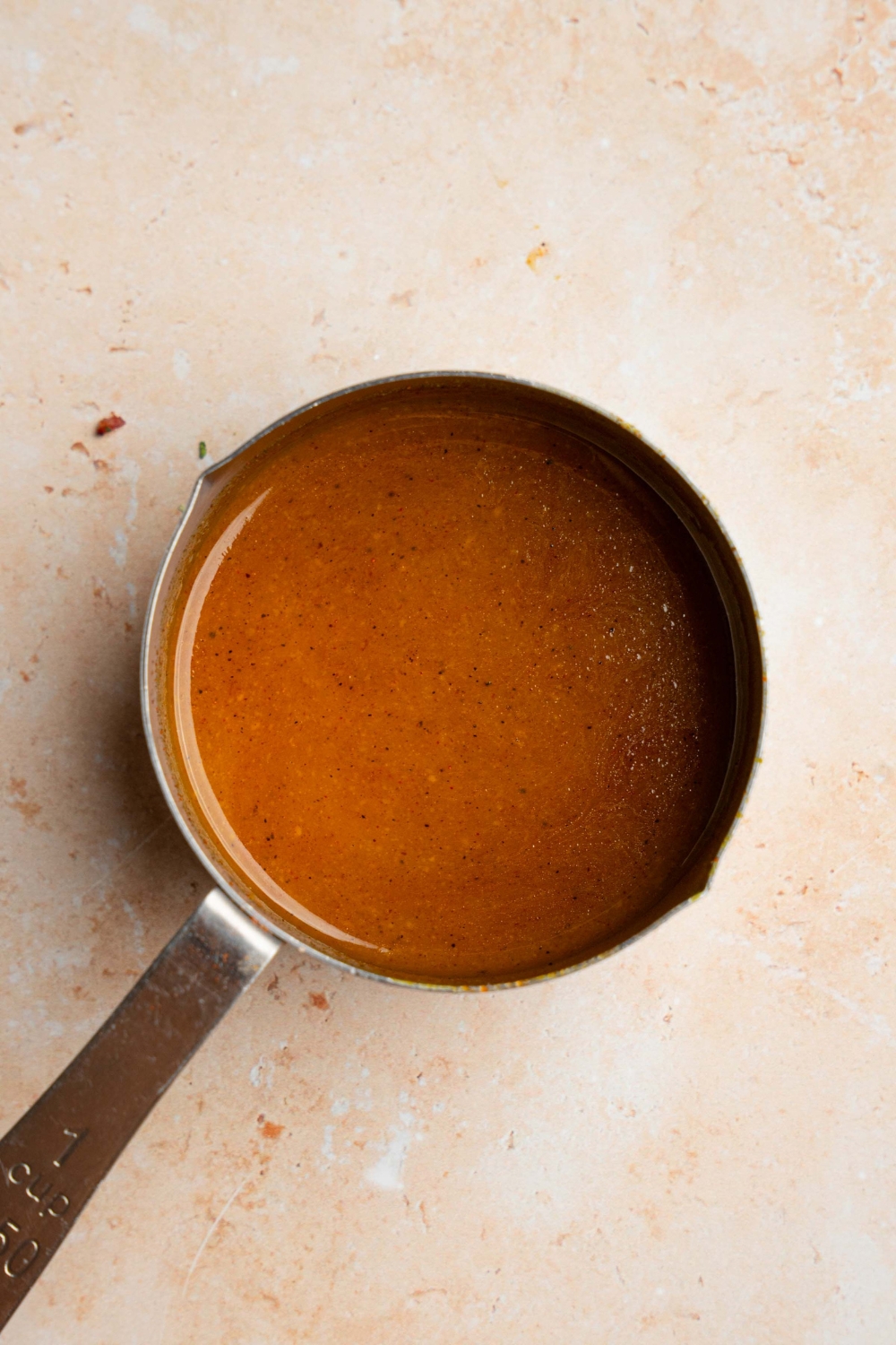 A small saucepan with cooked McDonald's golden sauce. The pot is on a tan counter.