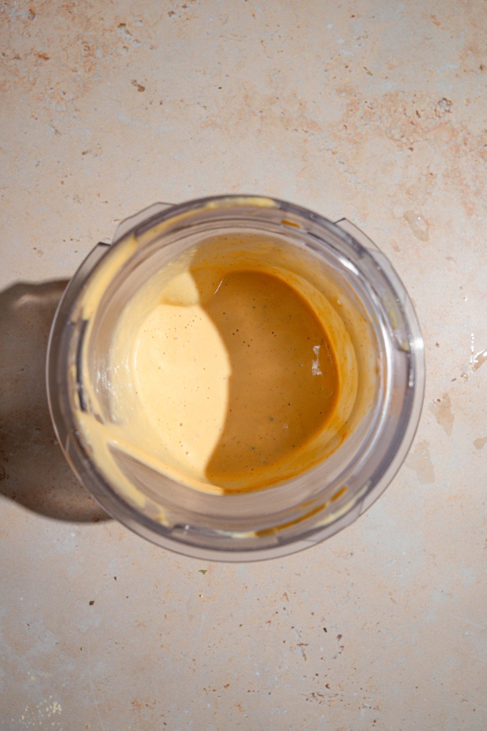 A glass blender jar filled with mixed Shake Shack sauce. The jar is on a tan counter.