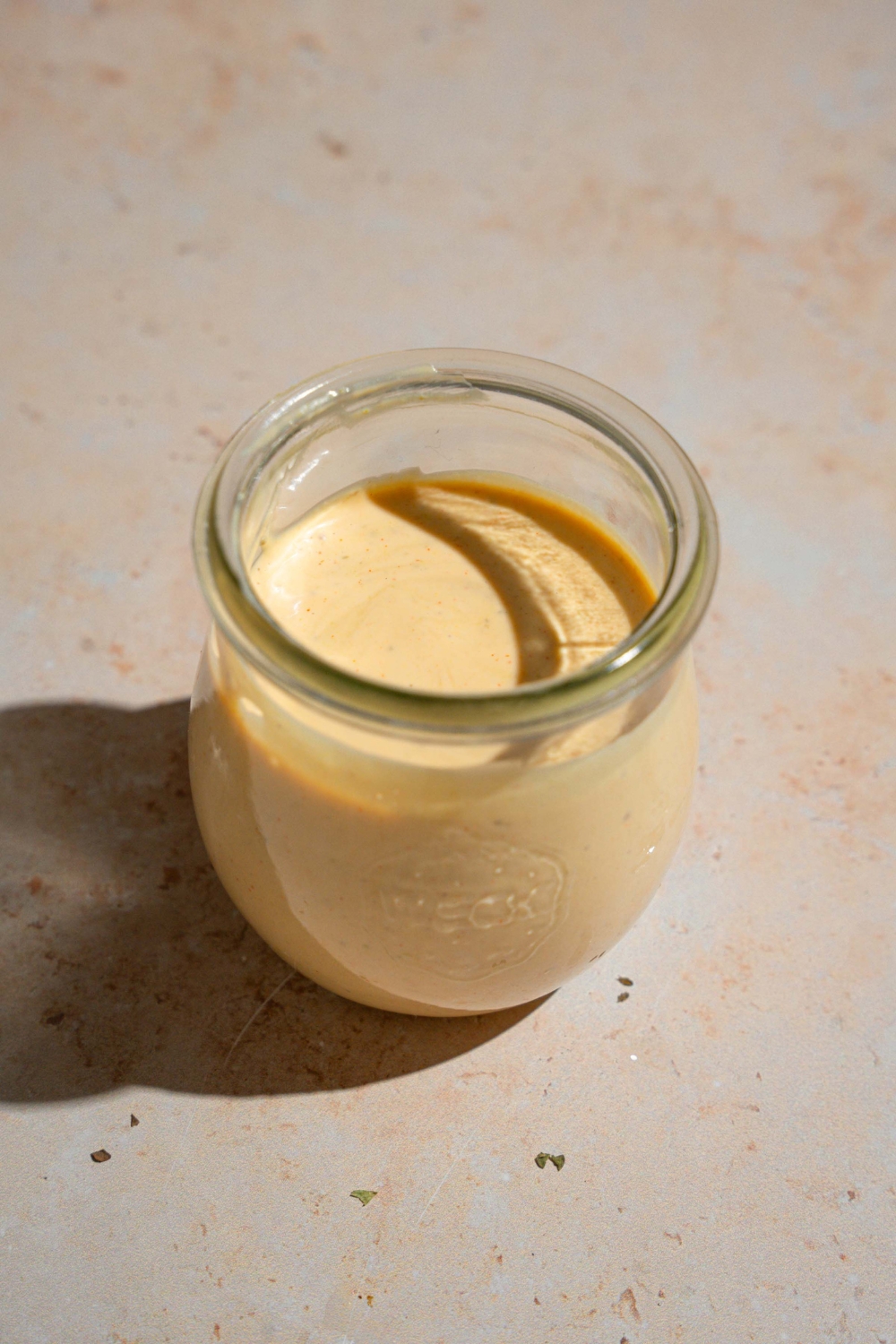 A jar of Shake Shack sauce on a tan counter.