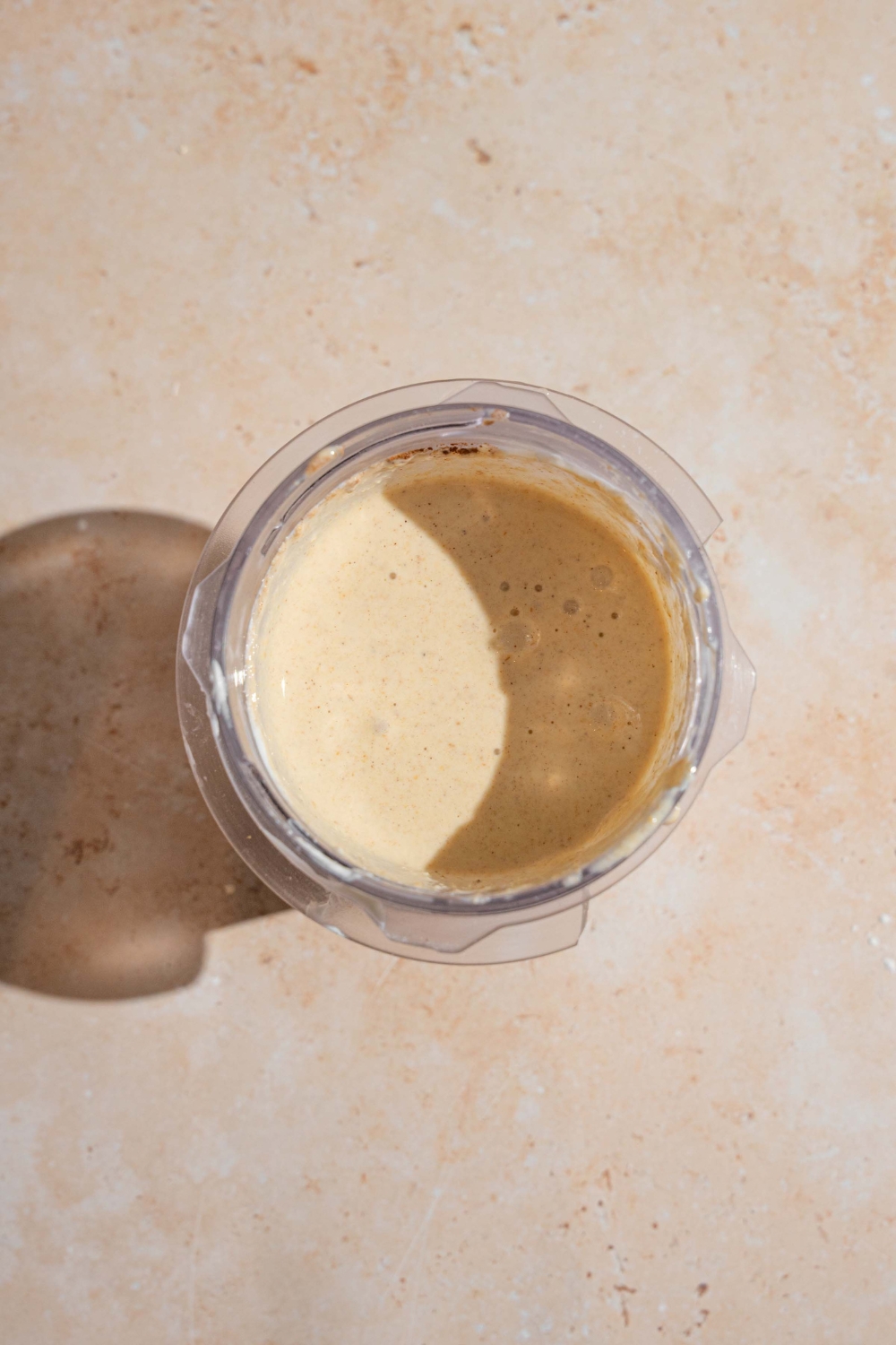 A jar with cottage cheese banana pancake batter. The jar is on a tan counter.