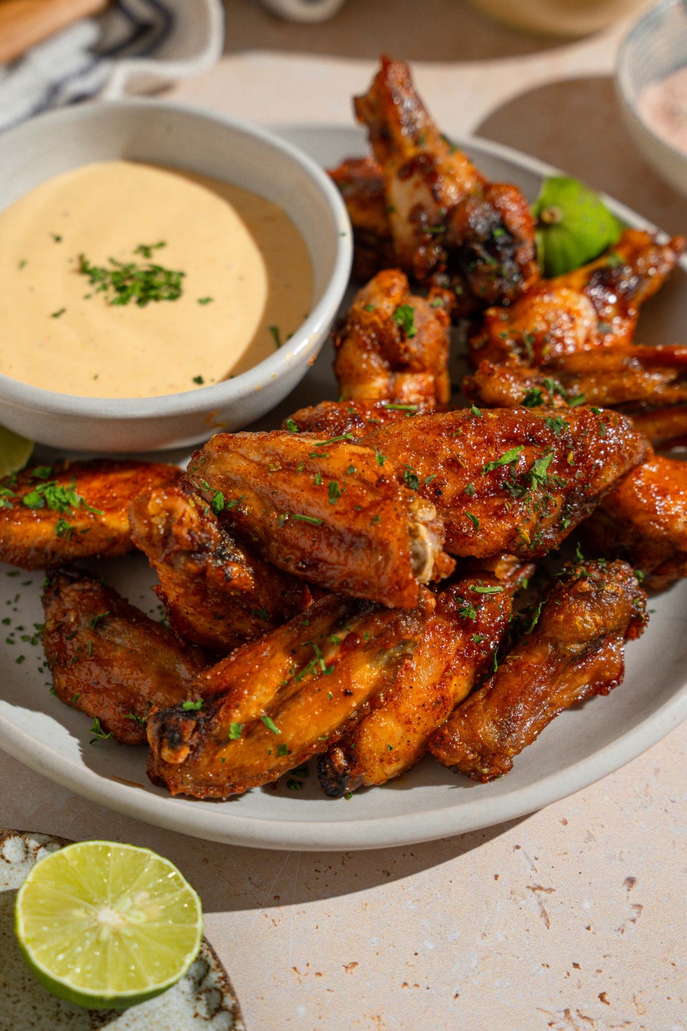 A bowl of baked wings tossed in Wingstop Louisiana rub. The bowl is on a tan counter.