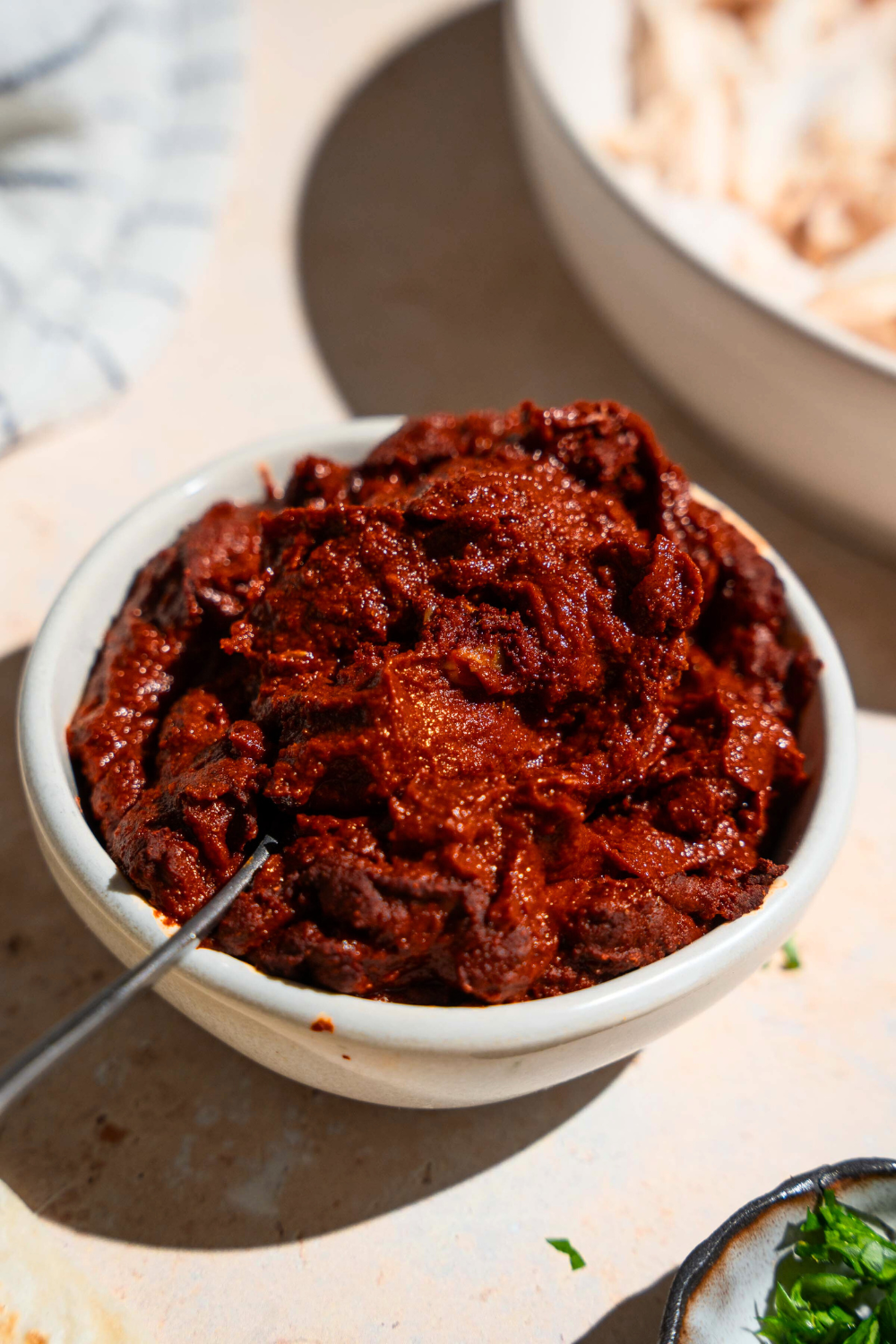 A white bowl that is overflowing with adobo sauce.