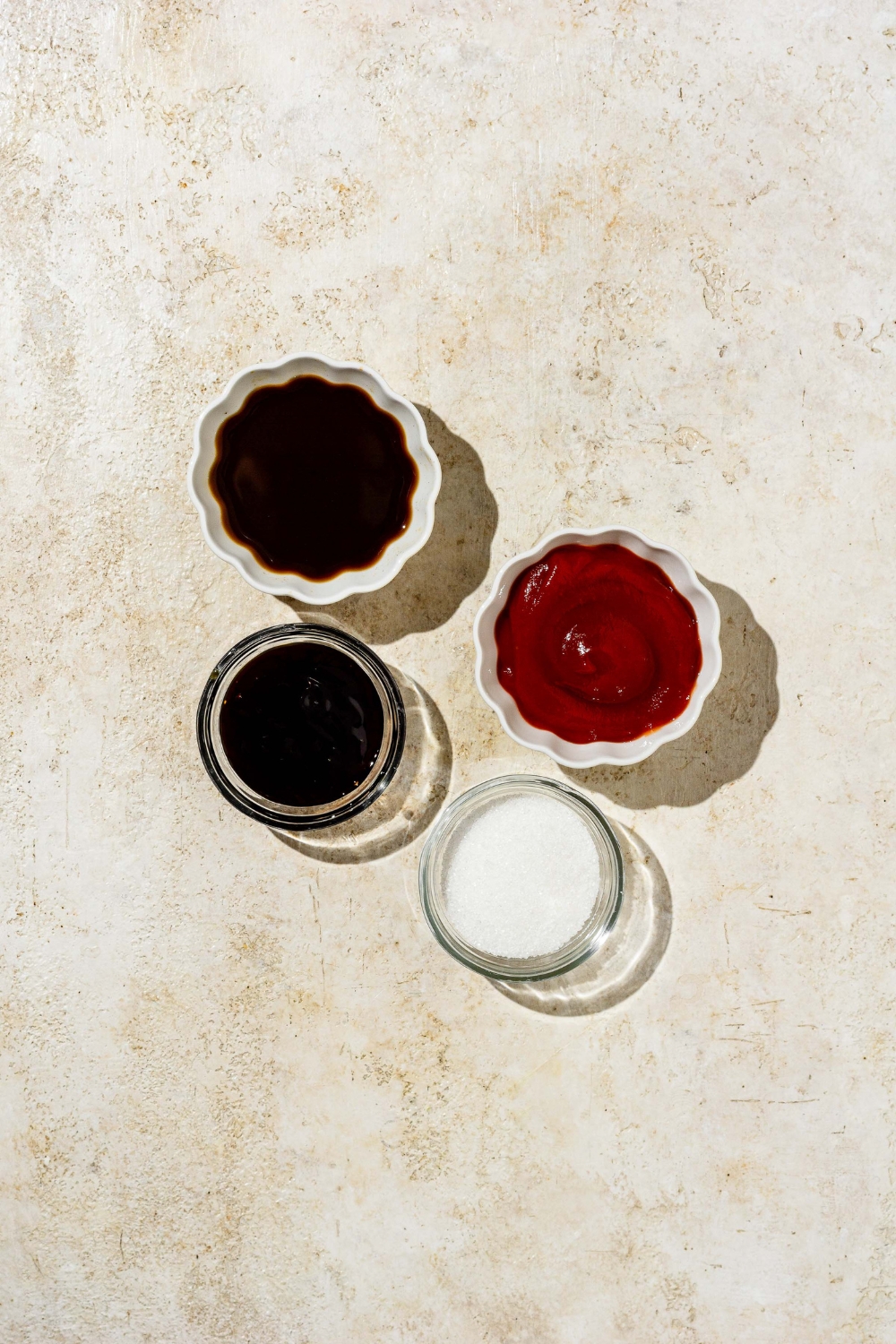 An overhead shot of several bowls in various sizes containing ingredients to make chicken Katsu including Worcestershire sauce, ketchup, sugar, and oyster sauce.