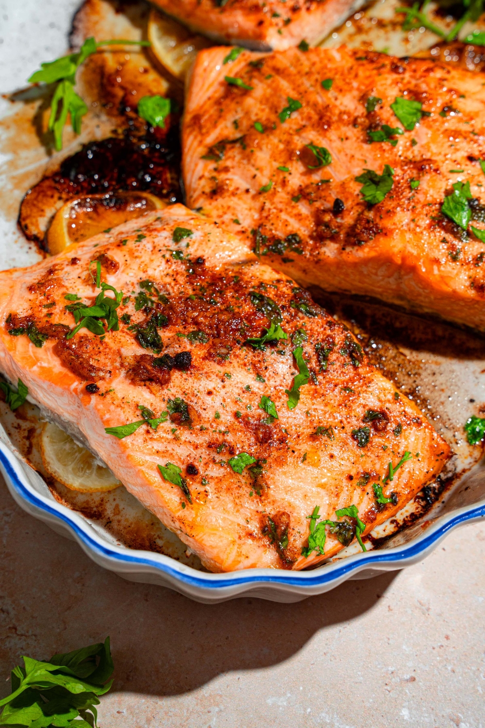A baking dish with several pieces of baked Sockeye salmon garnished with fresh parsley.