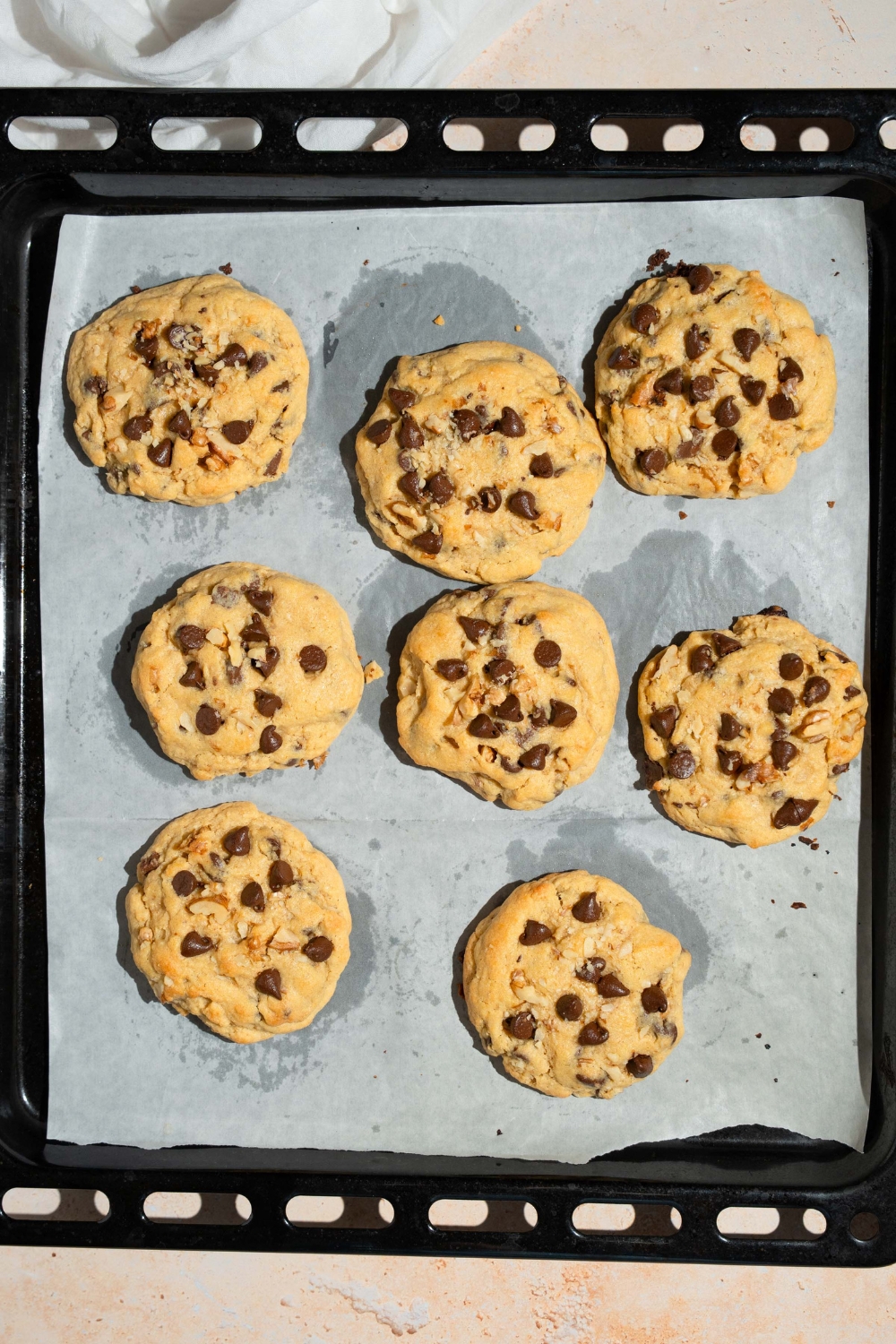 A lined baking sheet with several baked Neiman Marcus chocolate chip cookies.