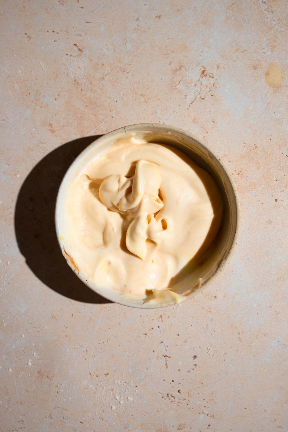 A small bowl of homemade Chick Fil A sauce. The bowl is on a tan counter.
