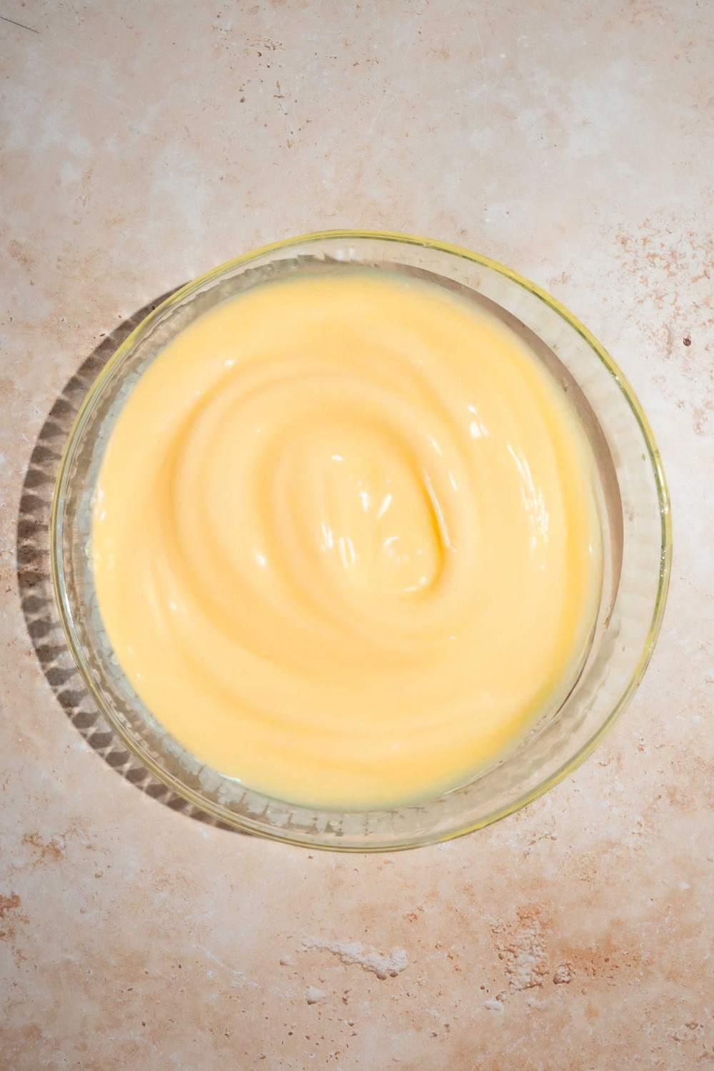 A lemon cake mixture in a glass baking dish on top of a white counter.
