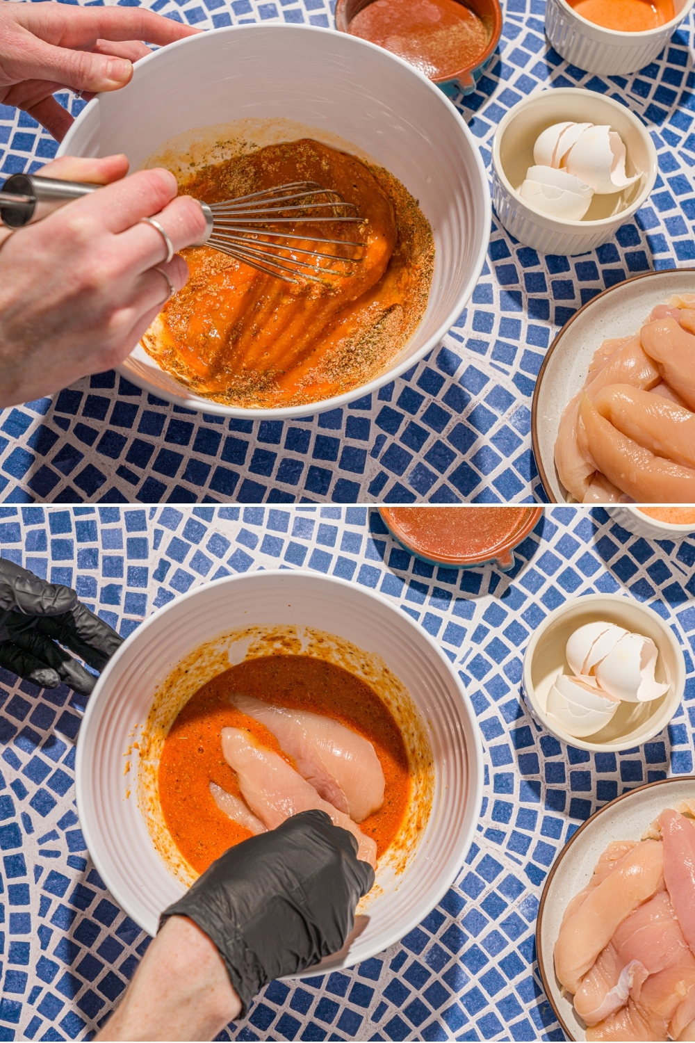 A photo of a hand whisking ingredients to make chicken tender seasoning. There is another bowl of chicken tenders dipped in the bowl. The bowl is on a blue tiled counter with a plate of chicken tenders and garlic.