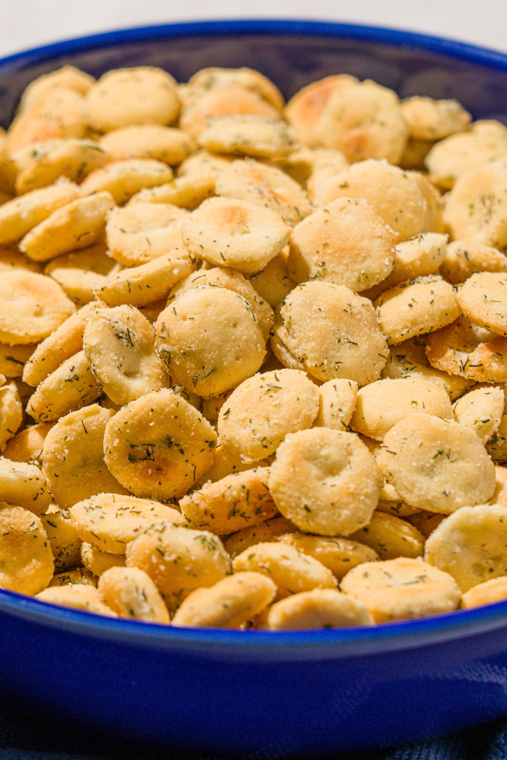 A blue bowl filled with ranch oyster crackers.