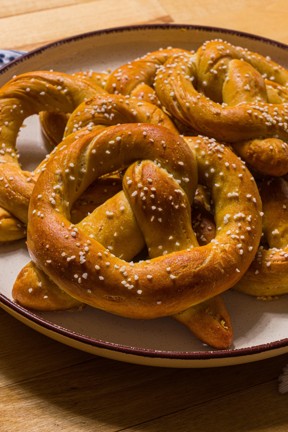 A white plate with copycat Auntie Anne's pretzels. The plate is on a wood counter.