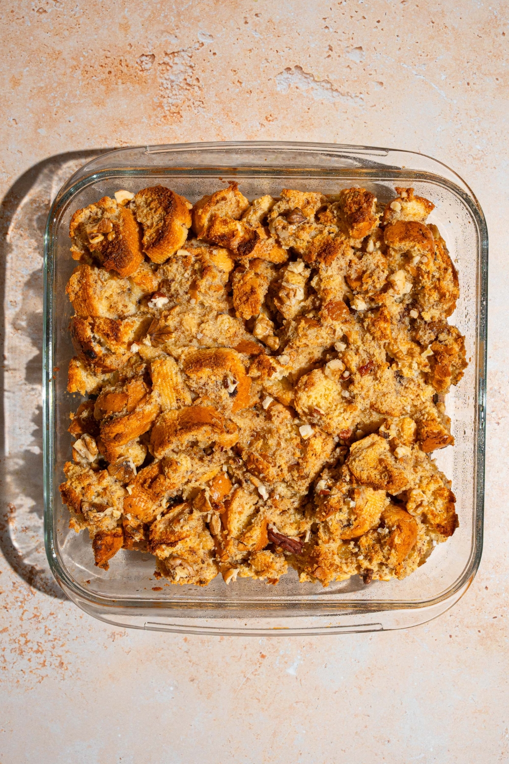 A baking dish with baked bread pudding. The dish is on a tan counter.