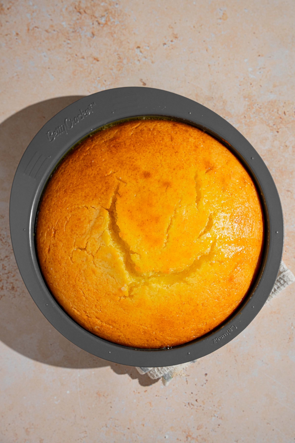 A cake pan with baked French butter cake. The pan is on a tan counter.