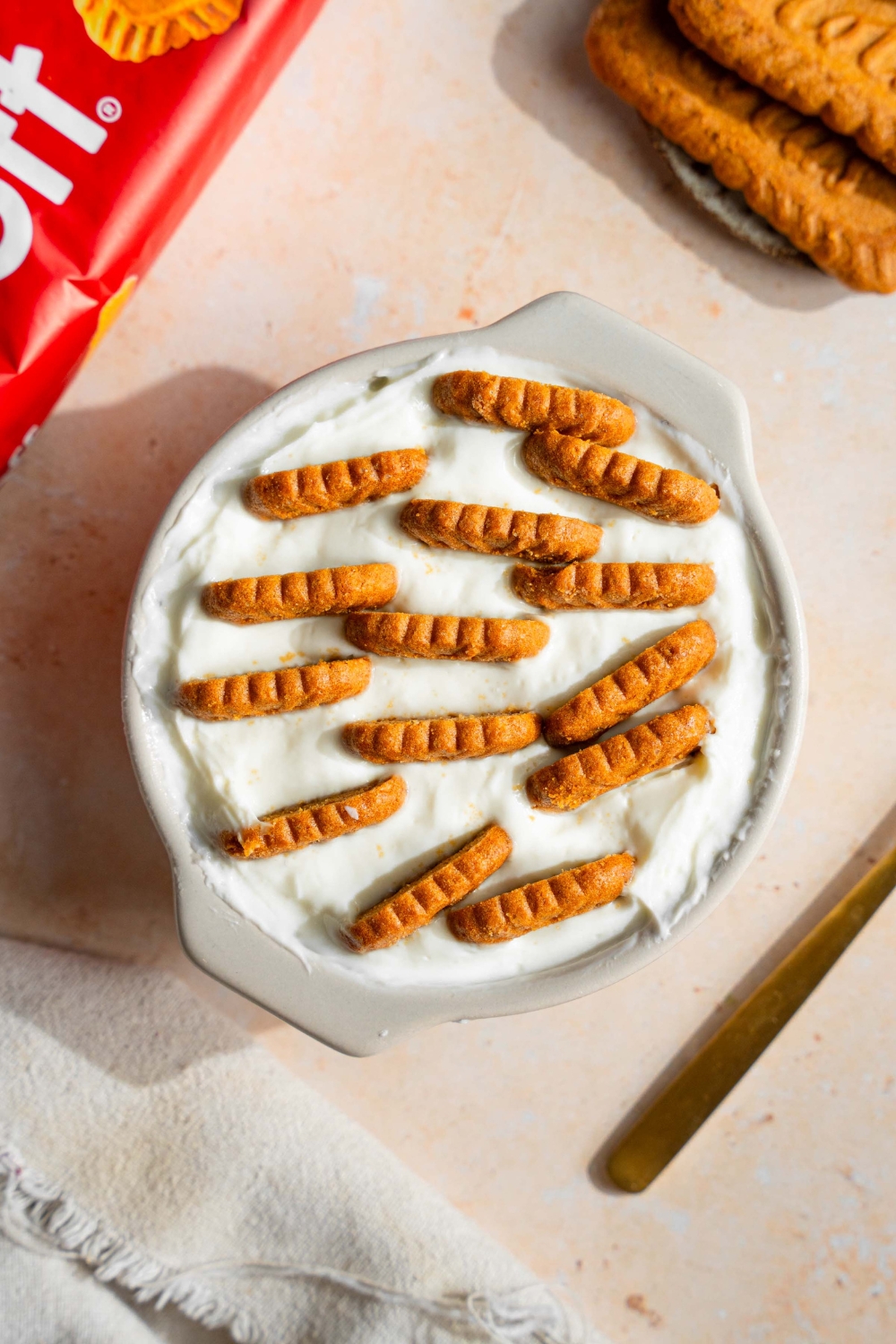 A bunch of Biscoff cookies in a tub of yogurt.