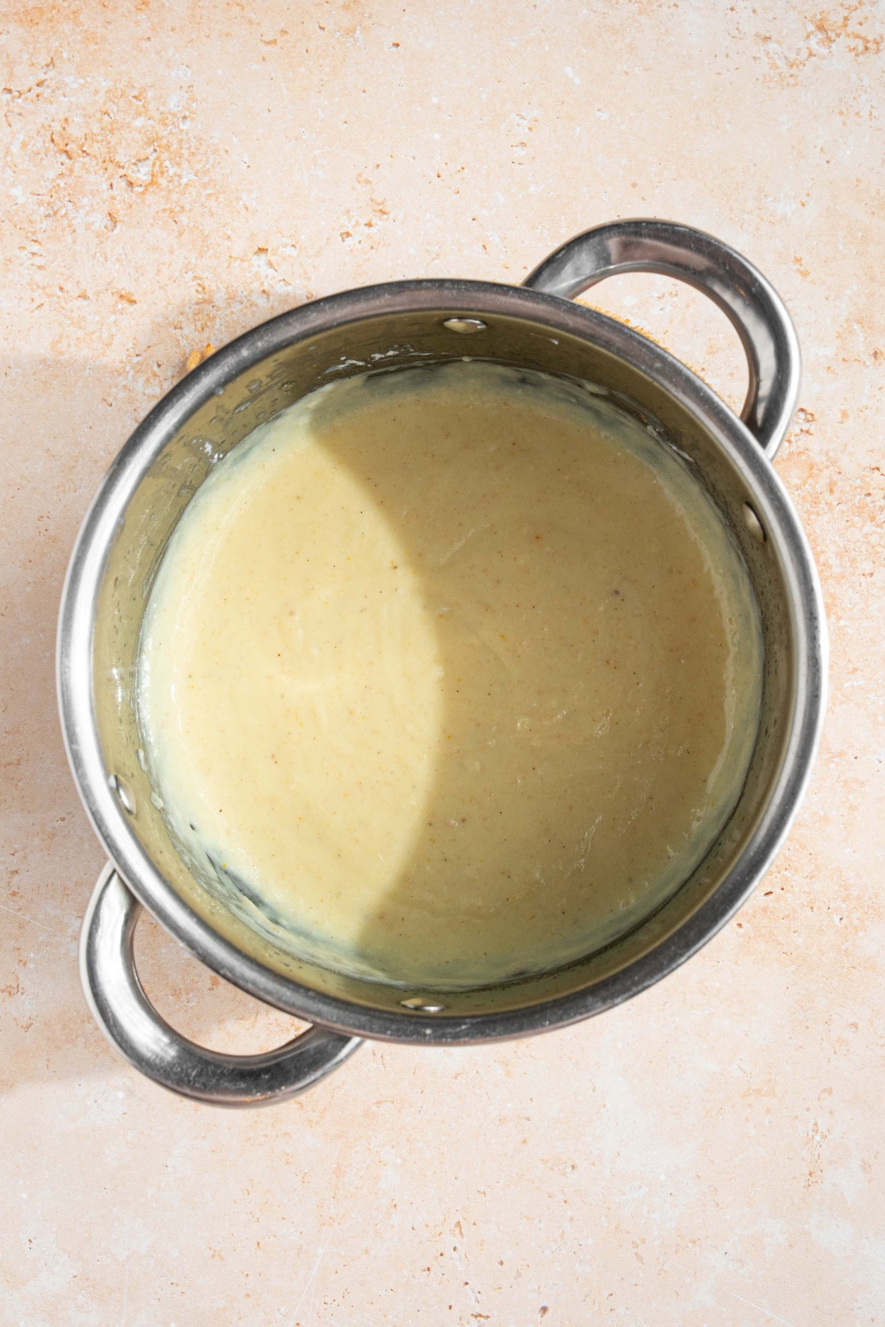A pot with cooked hello fresh cream sauce. The pot is on a tan counter.