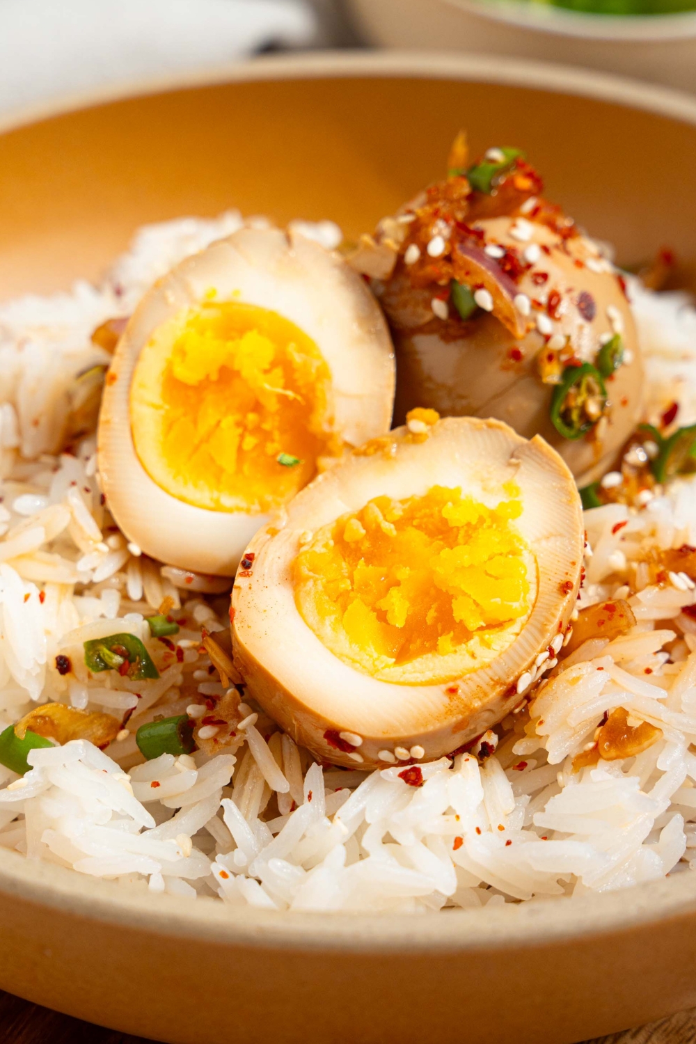 A sliced Korean drug egg and a whole Korean drug egg on top of white rice.