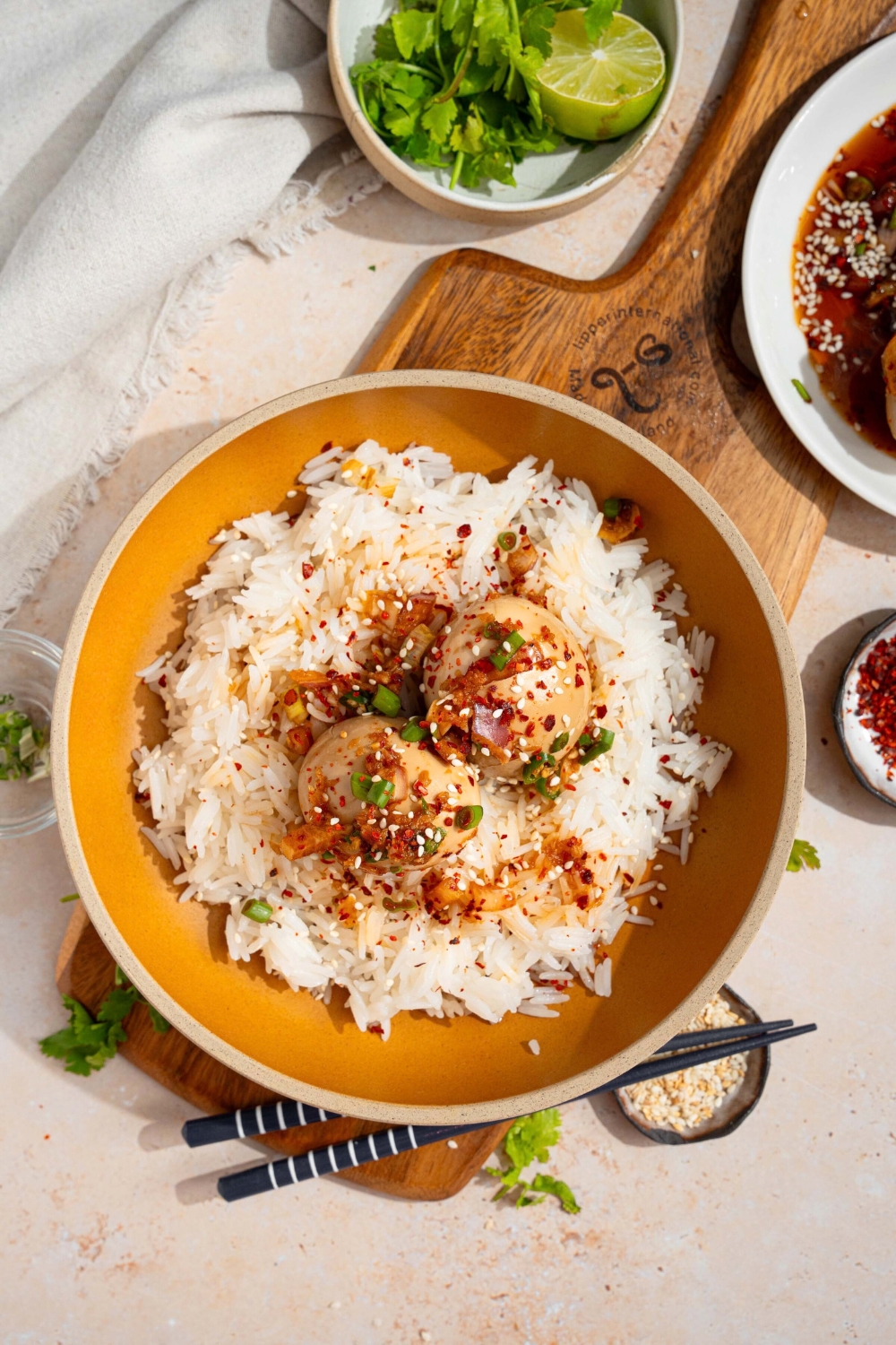 Two Korean drug eggs on top of white rice in a orange bowl.