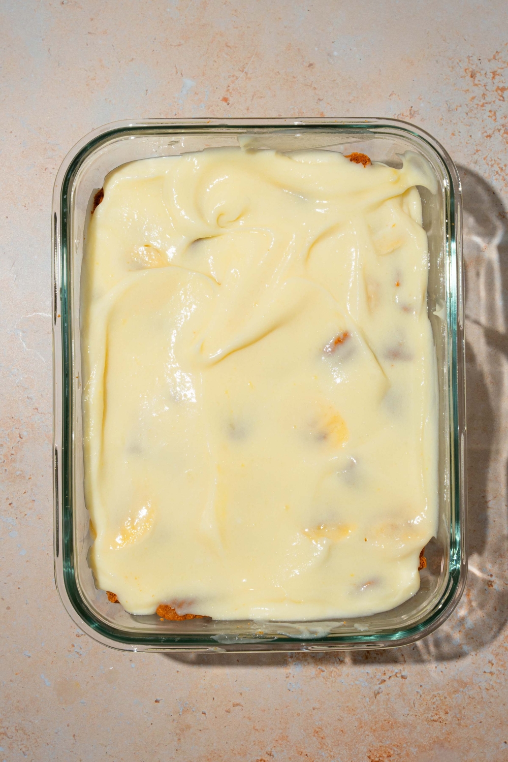 A baking dish with Biscoff banana pudding topped with a pudding layer. The dish is on a tan counter.