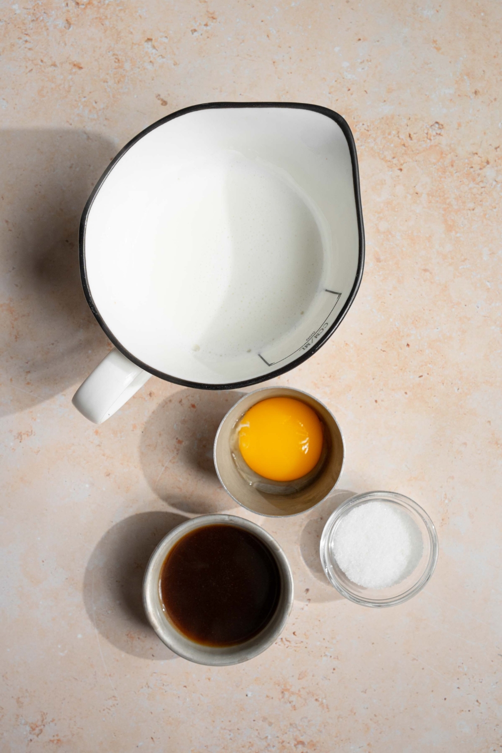 An overhead shot of ingredients to make Vietnamese egg coffee including coffee, egg yolk, sugar, and milk.
