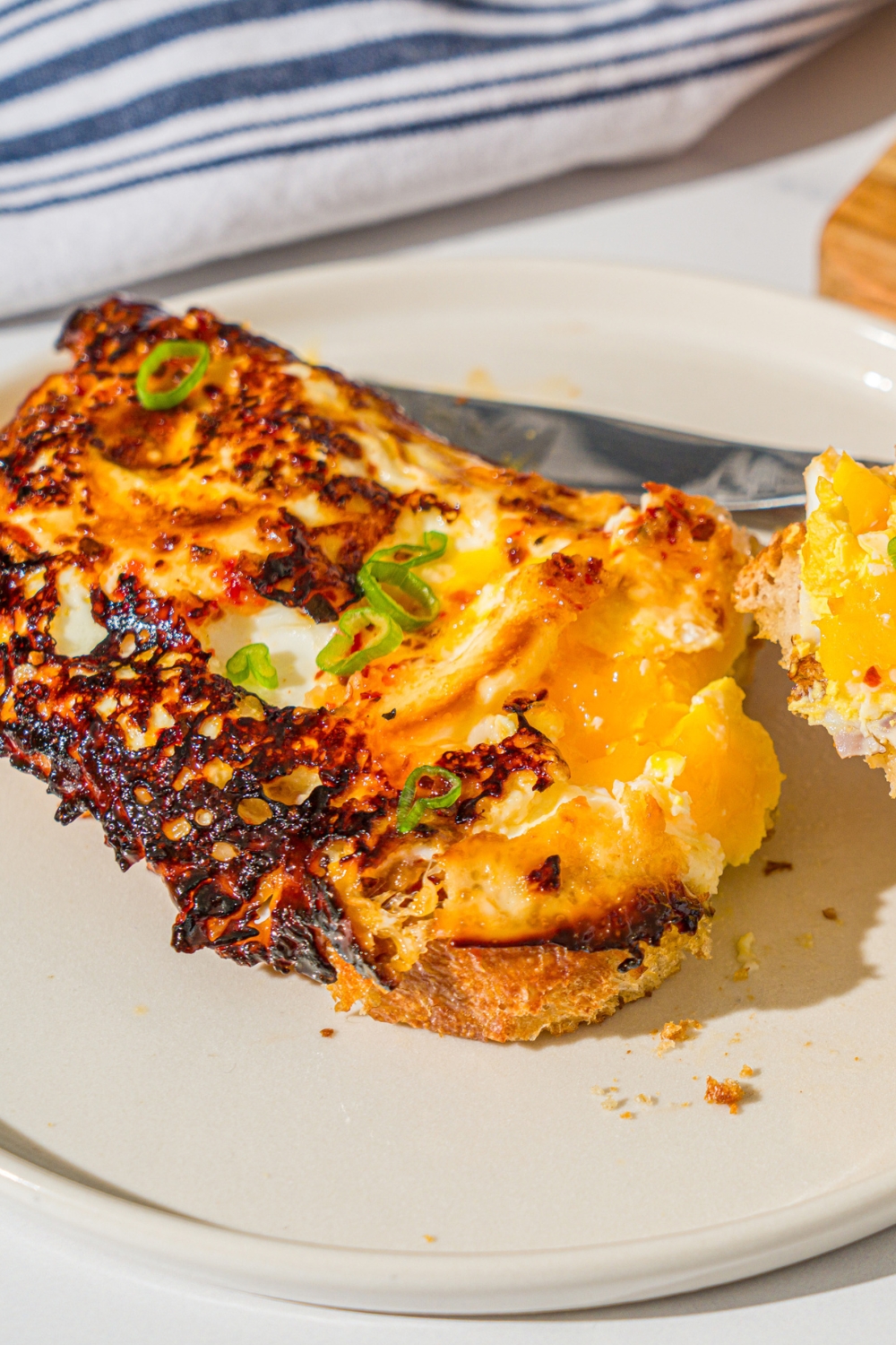 Hot honey eggs on top of a toasted piece of sourdough bread on a white plate.
