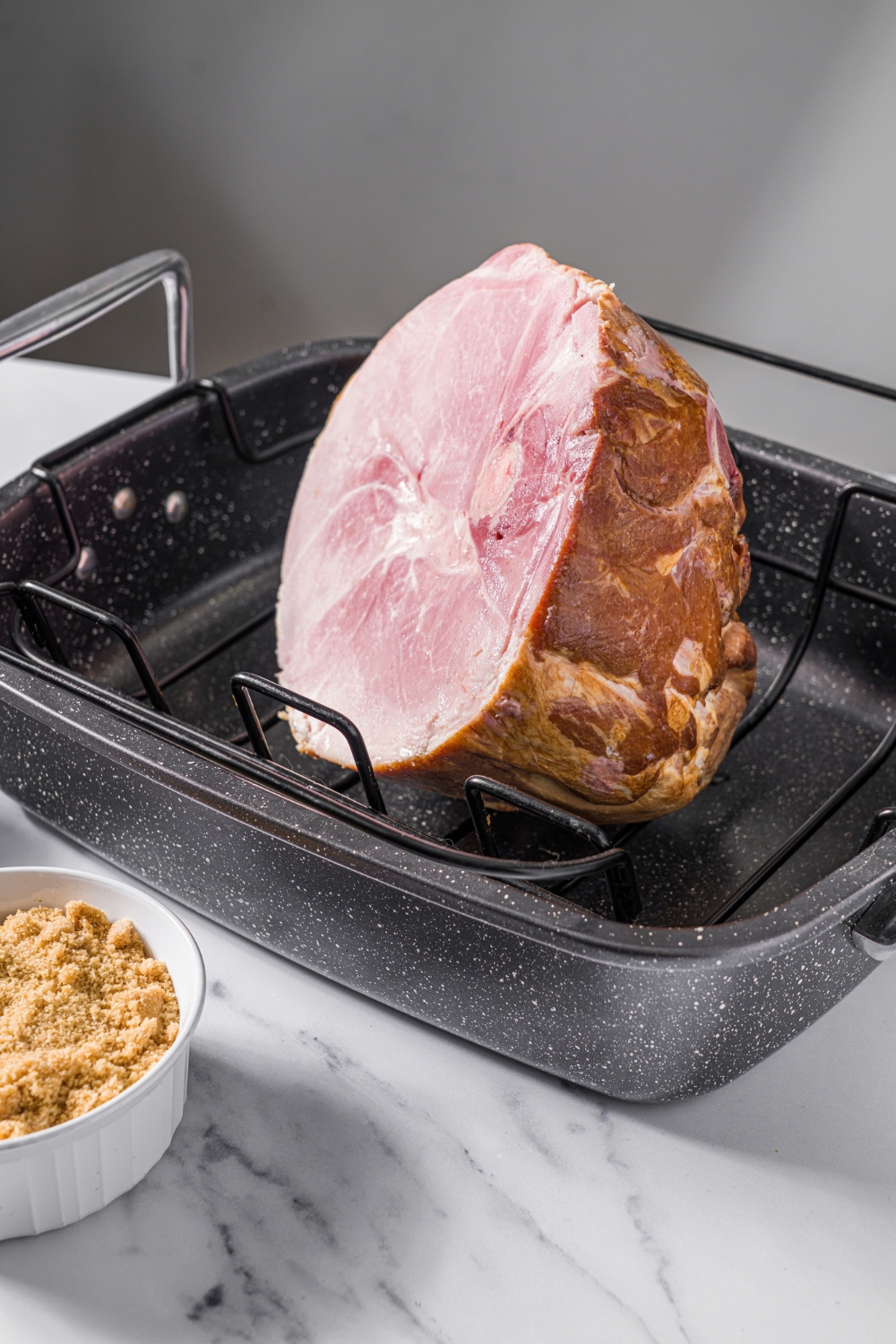 A ham shank in a roasting pan.