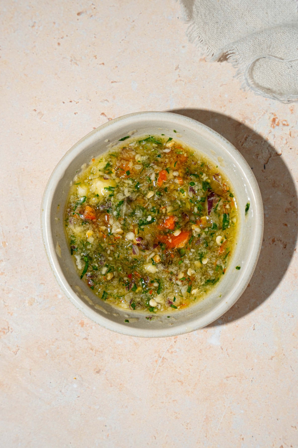 A small white bowl of crack sauce. The bowl is on a tan counter with a white cloth napkin.