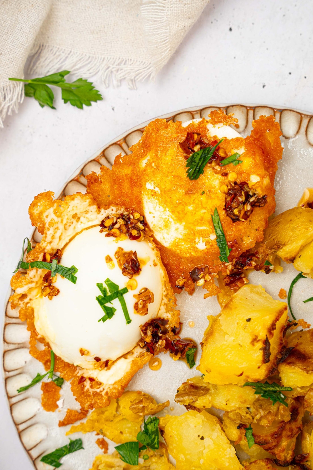 Two crispy feta eggs on a white plate.