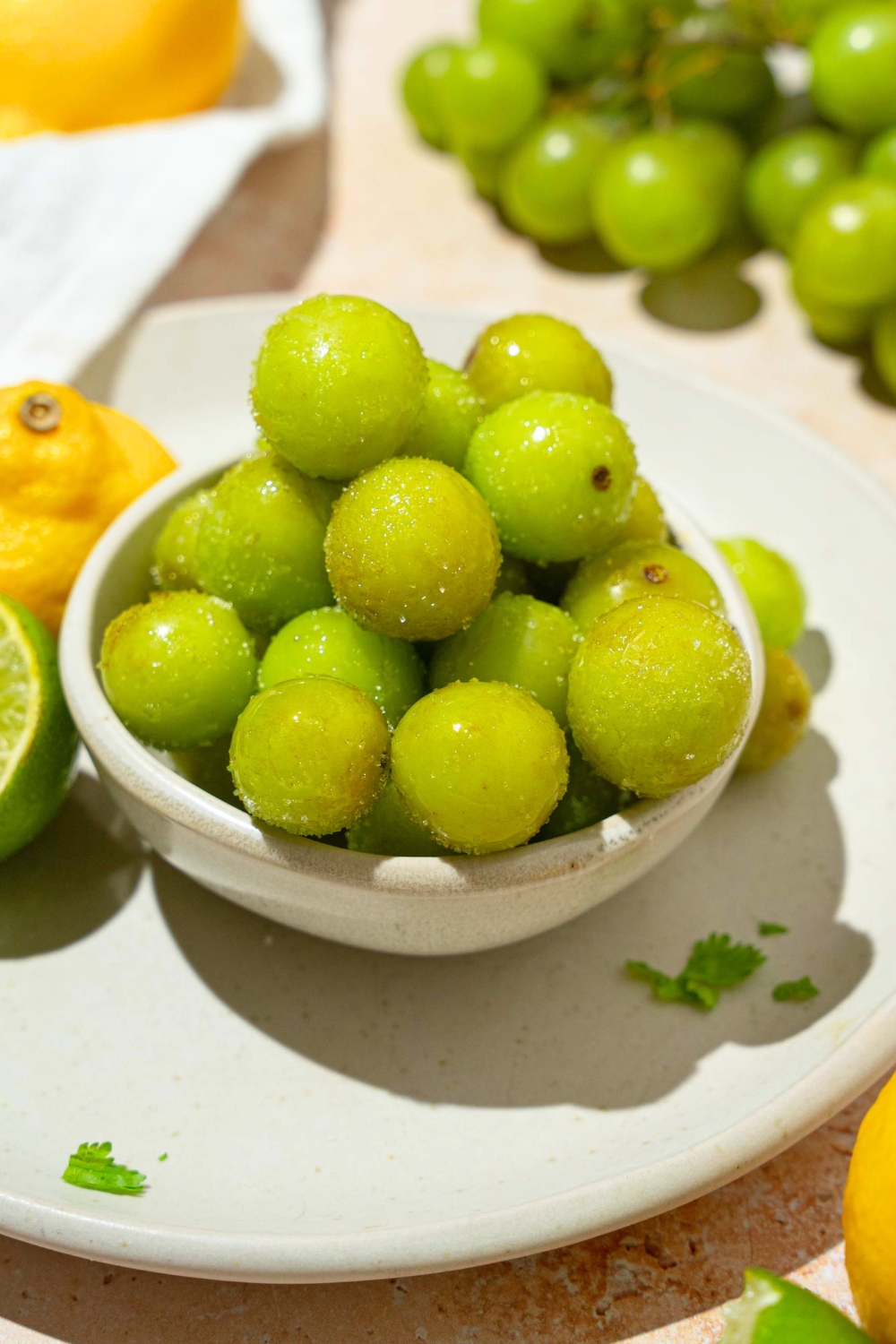A bunch of frozen sour grapes in a white bowl.