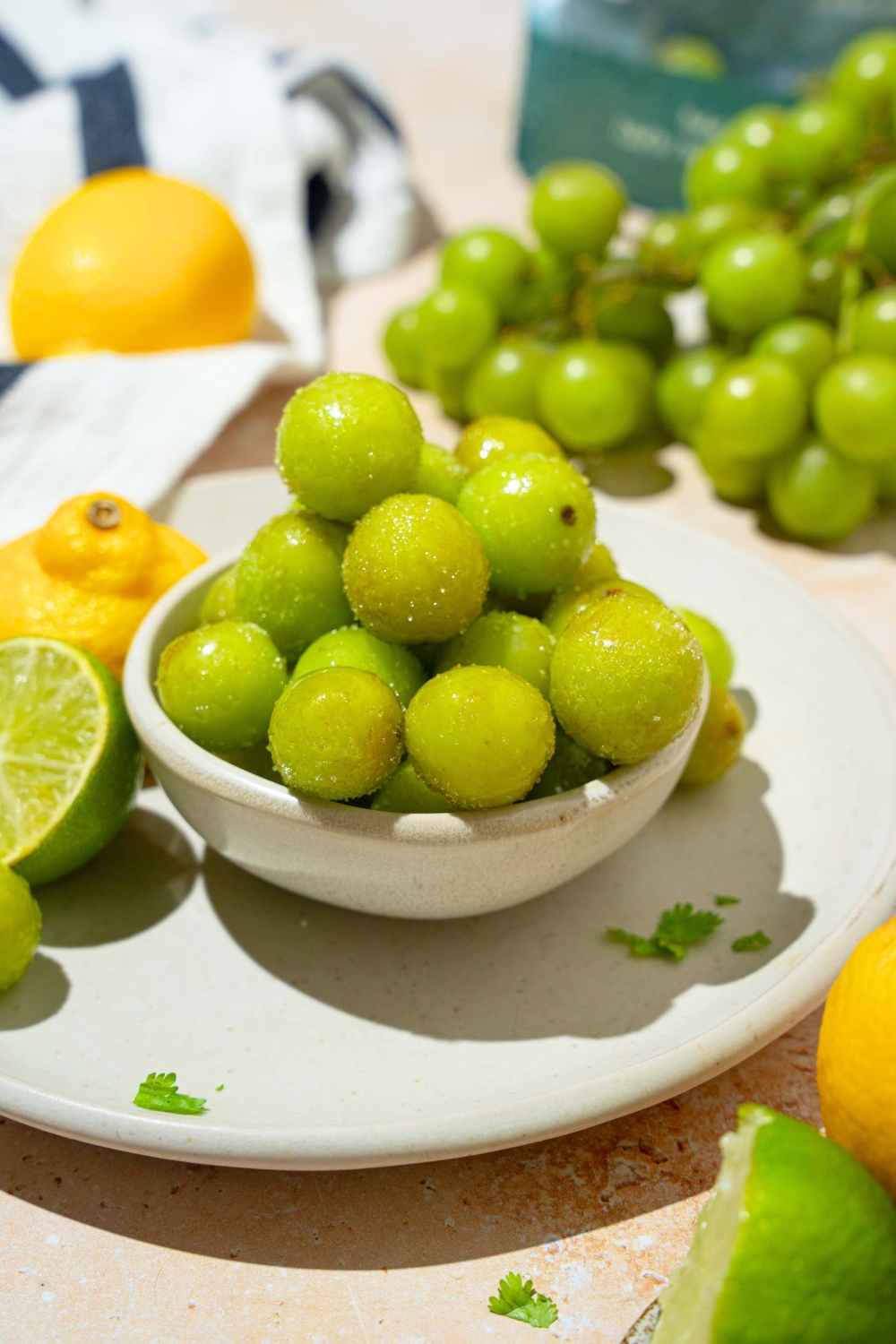 A bunch of frozen sour grapes in a white bowl.