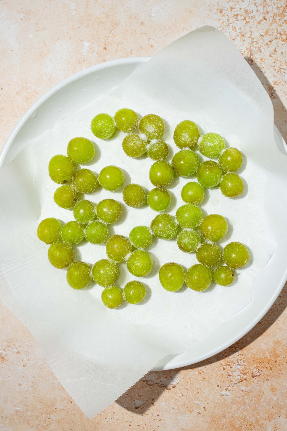 A bunch of green grapes on a paper towels on a white plate.