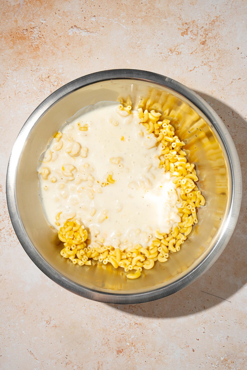 A cream sauce and pasta noodles in a bowl.