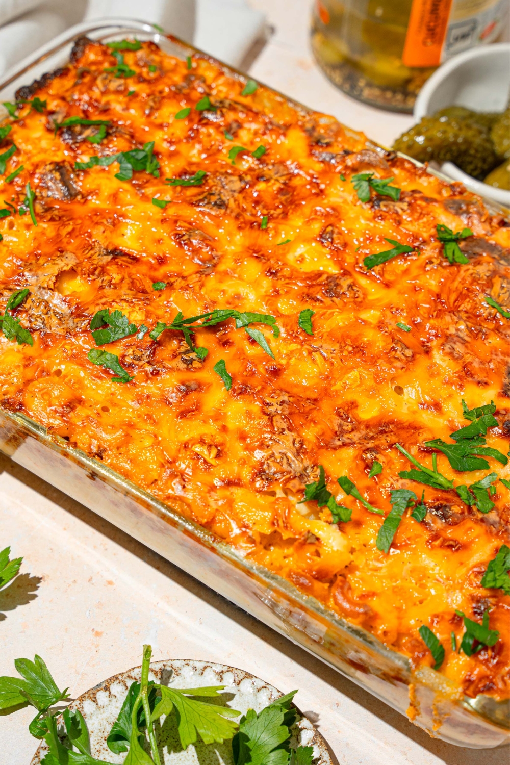 Part of a glass baking dish with a mac & cheese lasagna in it.