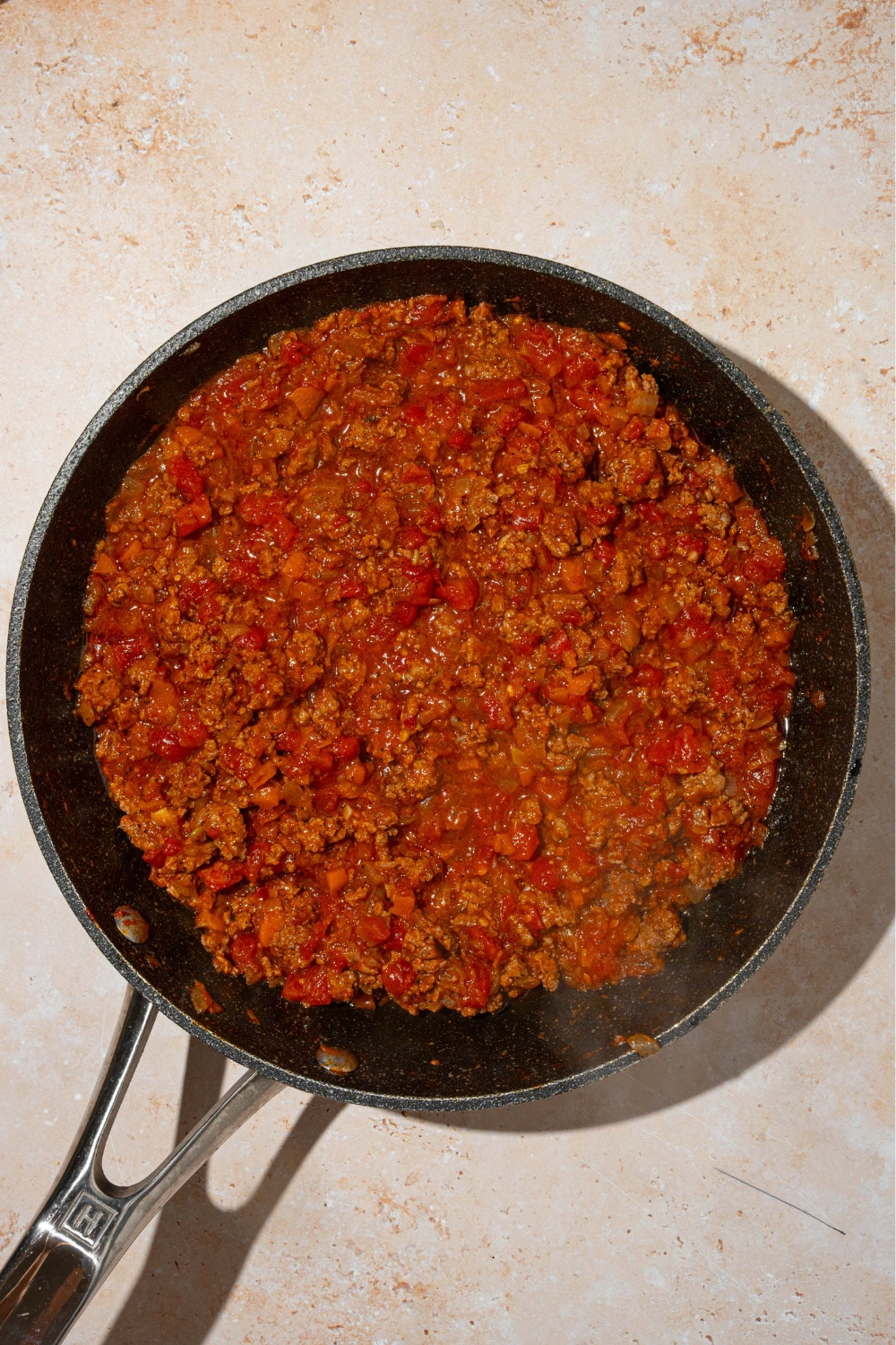 A homemade meat sauce in a black skillet.