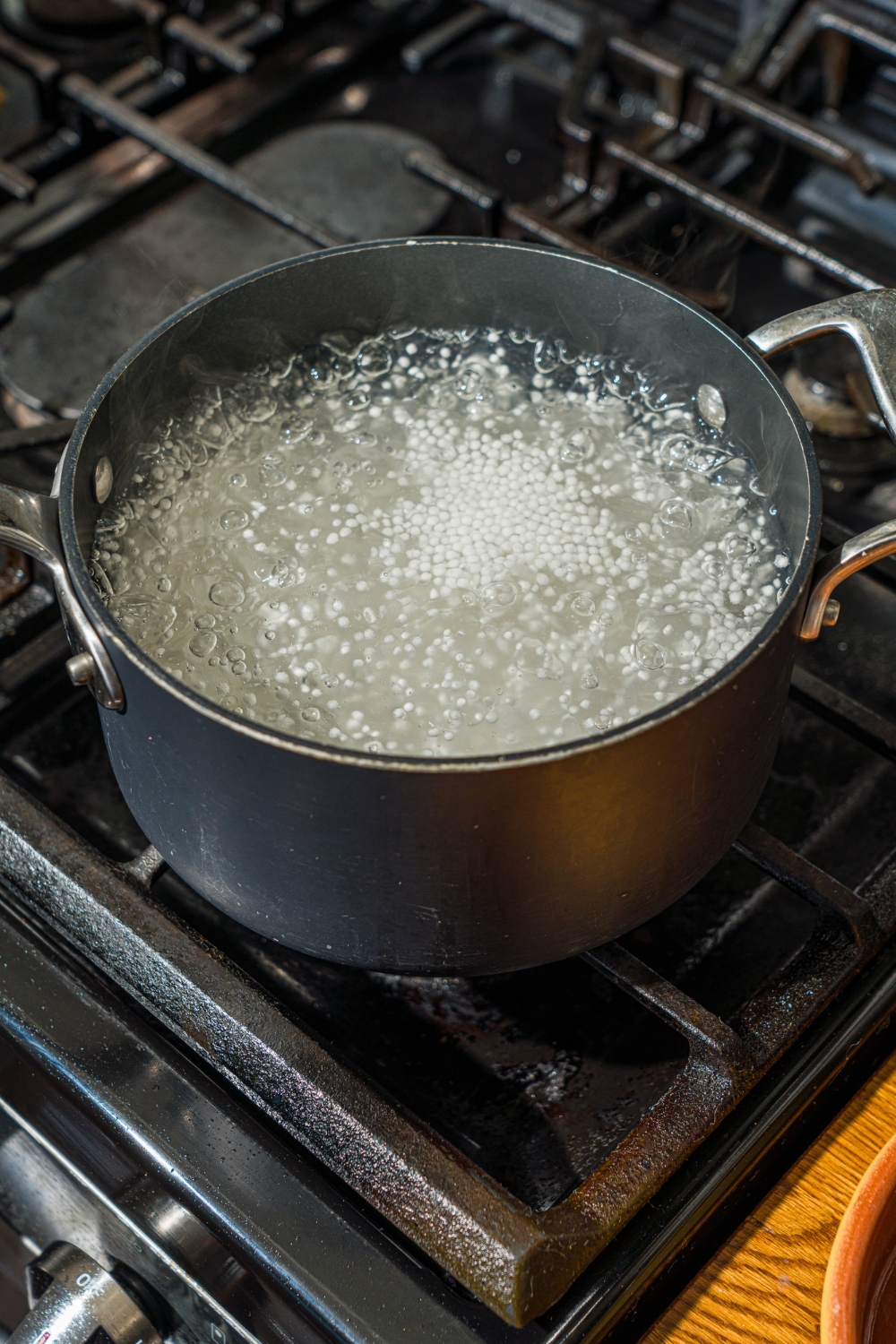 A pot with sago pearls cooking in water on the stove.