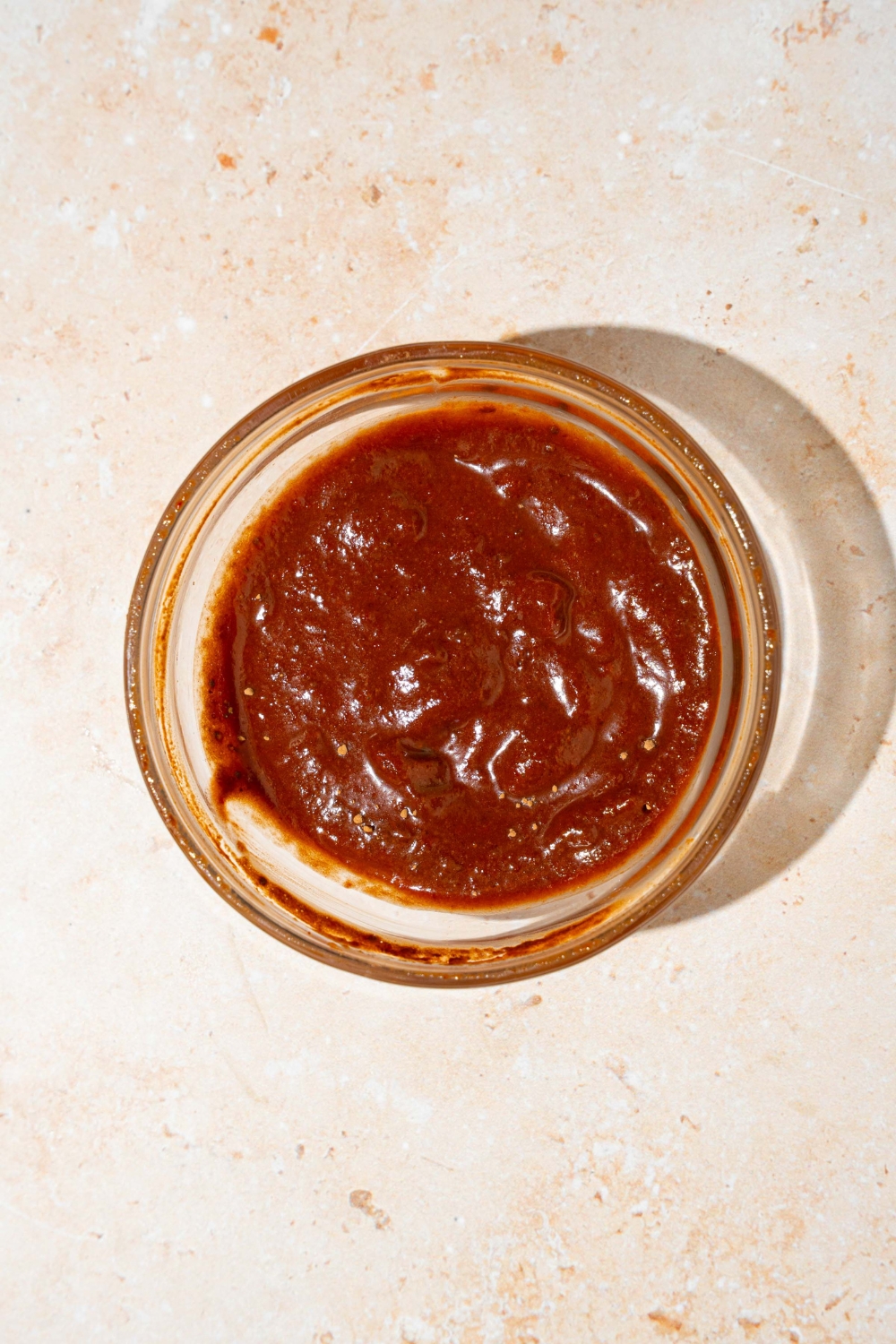 A glass jar with blended Tex Mex paste. The jar is on a tan counter.