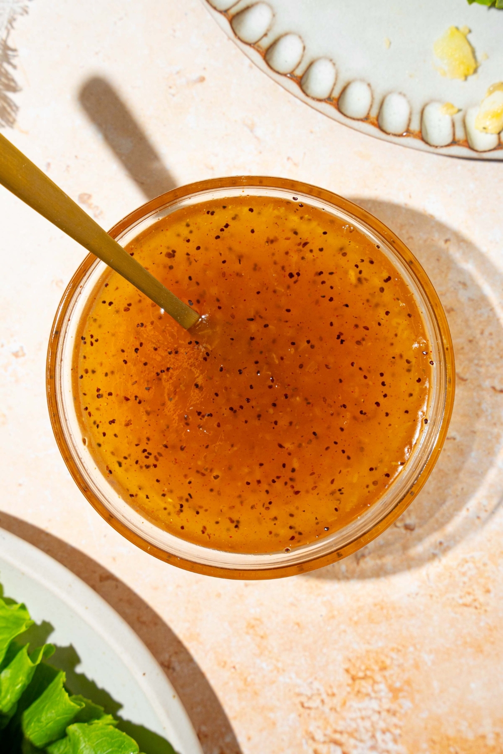A bowl of sweet onion sauce with a spoon in the bowl. The bowl is on a tan counter.