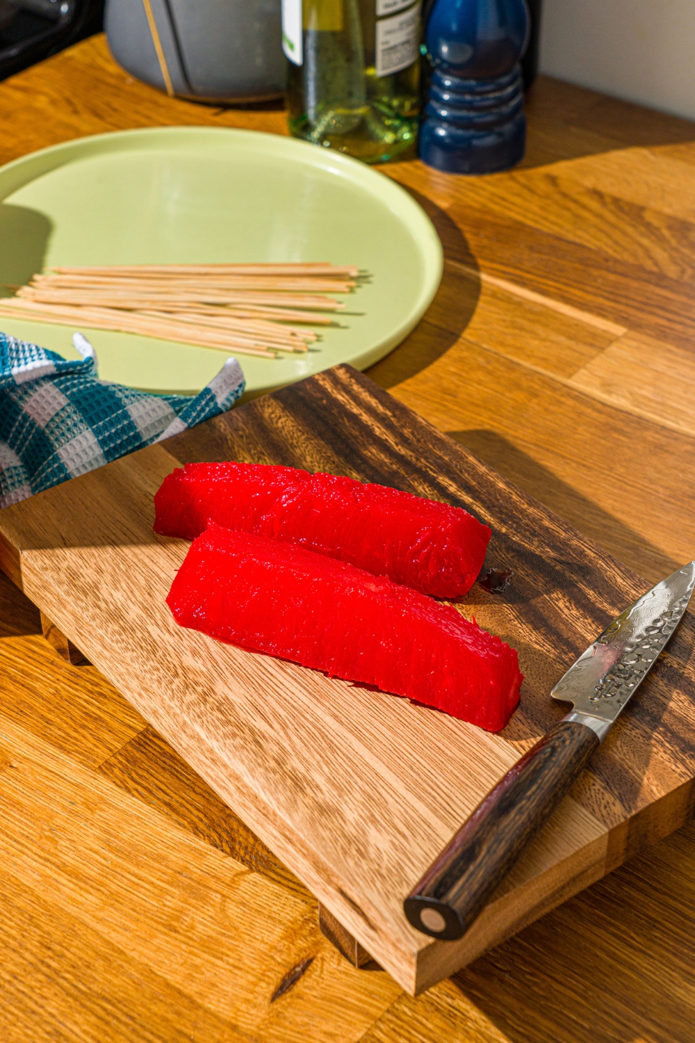 Two Kool-Aid pineapple spears on a wooden cutting board.