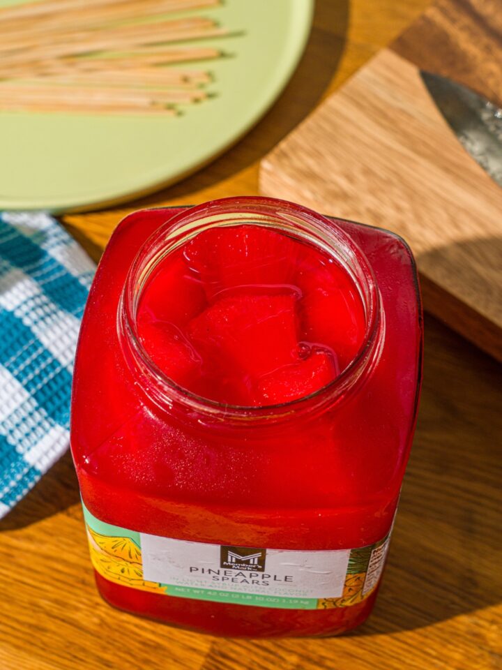 A pineapple jar that is filled with fruit punch, Kool-Aid pineapple spears.