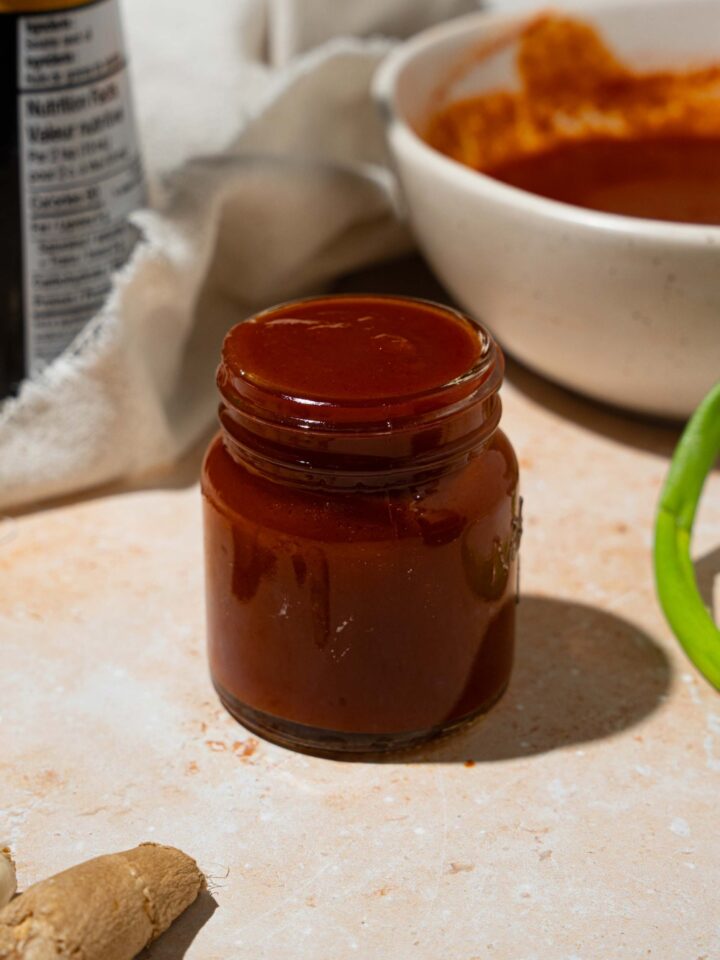 A jar of copycat Bachan Japanese BBQ sauce. The jar is on a tan counter with a large bowl of sauce.