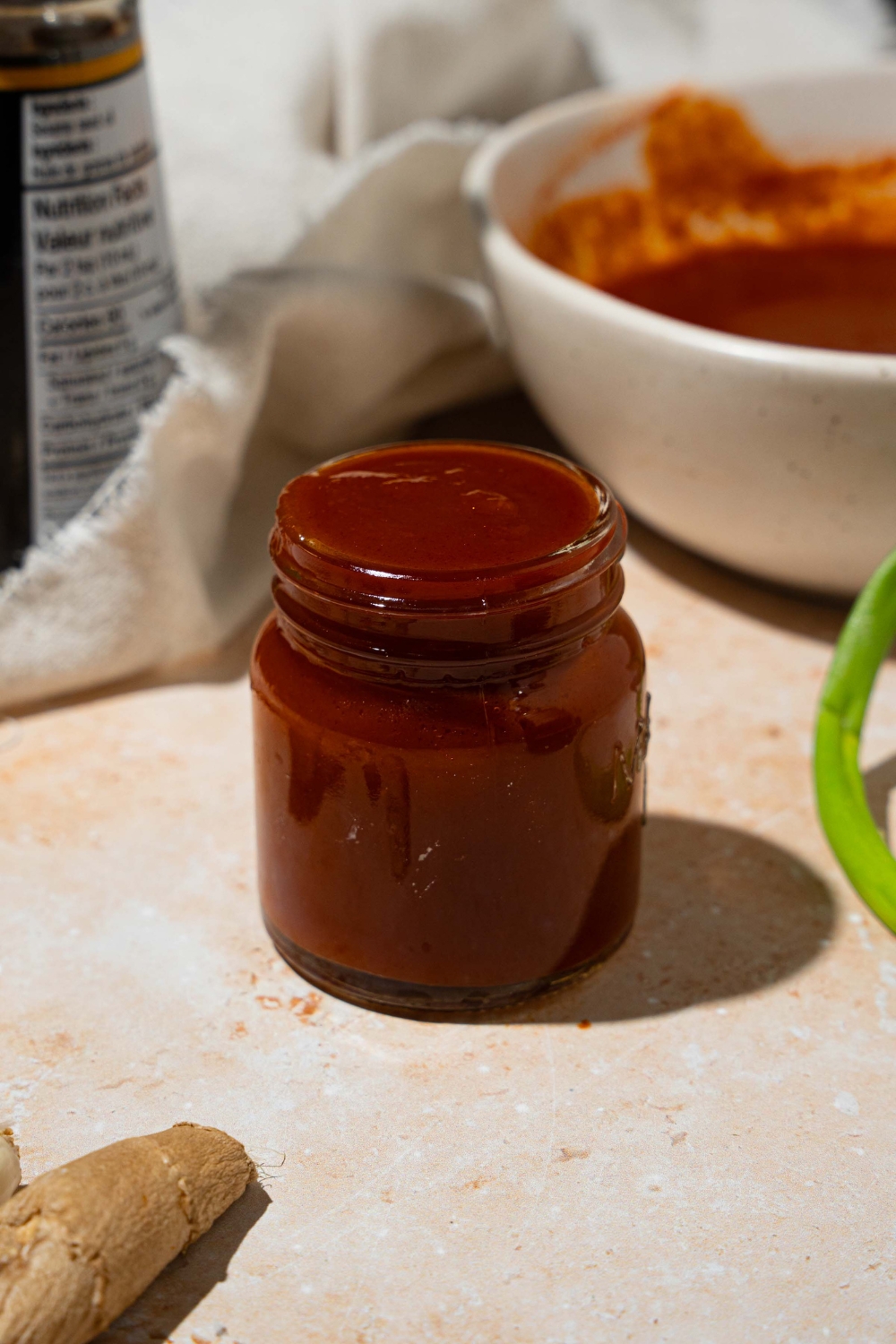A jar of copycat Bachan Japanese BBQ sauce. The jar is on a tan counter with a large bowl of sauce.