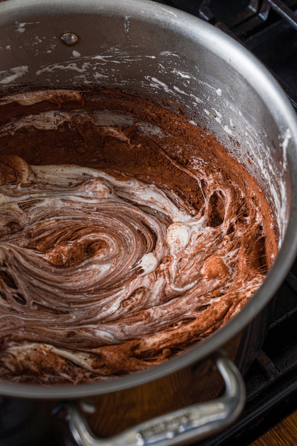 A large pot with cocoa powder and milk powder mixed with a melted marshmallow mixture.