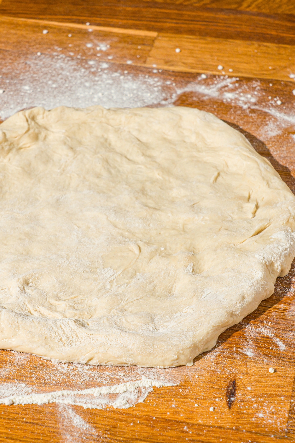 A floured surface with stretched pizza dough.