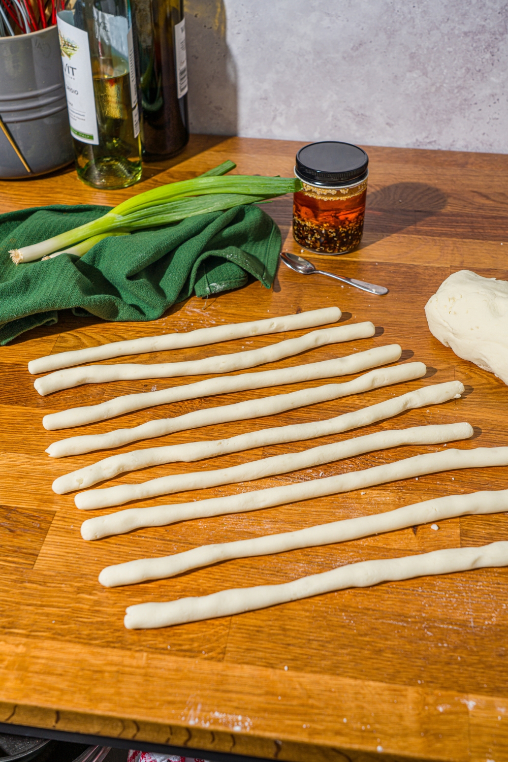 A wooden counter with several rolled potato dough noodles.