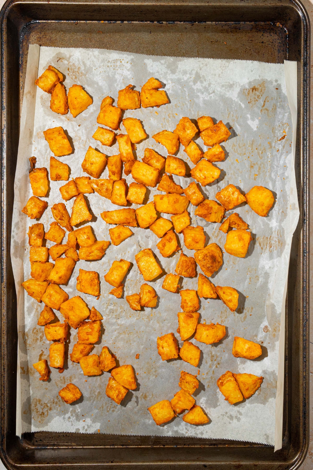 A baking sheet lined with parchment paper with baked fiesta potatoes.