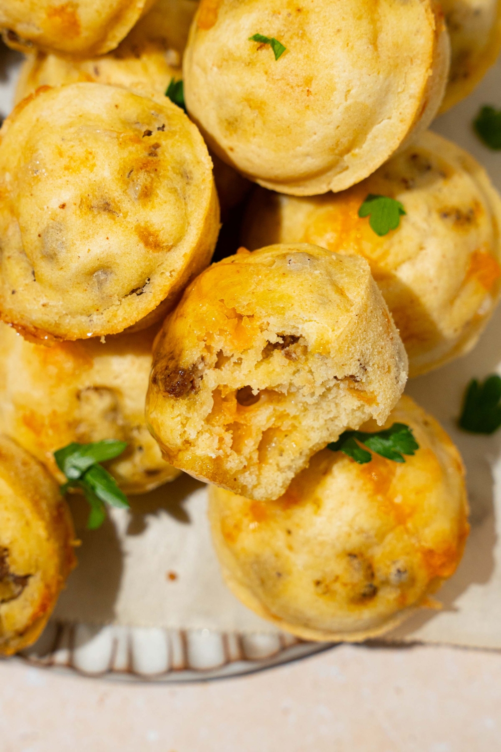 A plate with a pile of McGriddle muffins garnished with fresh parsley. One of the muffins has a bite taken from it.