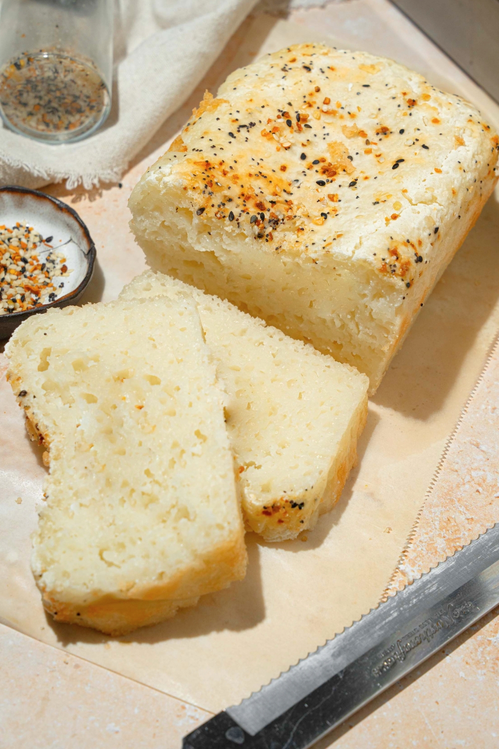 A loaf of blender rice bread with two slices of the bread in cut and laying on top of each other in front of it.